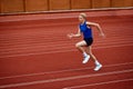 Burst of energy in running long jump. Young attractive sportsman running on sport court to make a perfect long jump to Royalty Free Stock Photo