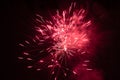 Burst of red fireworks at night - vibrant red streaks and sparks - smoke clouds - celebration, new years day, fourth of july, Royalty Free Stock Photo