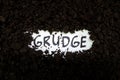 Bury grudge and stop holding concept. Grudge text word on soil backdrop. Royalty Free Stock Photo