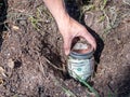 Burying a jar of money in the garden as savings, retirement or college fund concept.