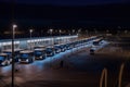 bus depot at night, with the lights on and buses ready to depart