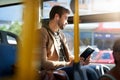 The bus is a great place to catch up on some reading. a handsome young man reading a book during his morning bus commute Royalty Free Stock Photo