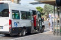 Bus of a local cooperative and foreign woman asking for information with a mask