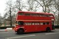A vintage double-decker red bus speeding on the streets of London England