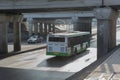 bus moves along the street under the bridge Royalty Free Stock Photo