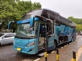 Modern Tour Bus Parked Beside The Sidewalk in Jakarta City Royalty Free Stock Photo