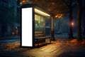 Bus stop with empty white vertical billboard on side for advertising mock up mounted in autumn city at night Royalty Free Stock Photo