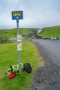 Bus stop and pile of backpacks at famous Skogafoss waterfall, while hiking in Iceland, summer, scenic dramatic view