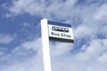 Bus stop sign sky background blue white clouds view below information public transport school old age pensioner travel free coach Royalty Free Stock Photo