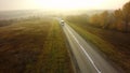 Bus traveling on the asphalt road in a rural autumn landscape at sunset Royalty Free Stock Photo