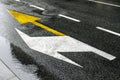 Bus yellow arrow showing straightforward and white left, signs on asphalt