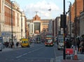 Buses traffic and people on the headrow in leeds with quarry house at the bottom of the road