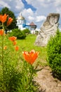 Orange lily flowerbed, modern neo pagan sculptures, russian orthodox church and ancient kozak tower Royalty Free Stock Photo