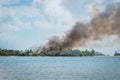 Bushfire, black smoke above burning forest - fire on tropical is Royalty Free Stock Photo