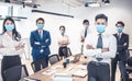 Busines people wearing face mask with presentation of business plan . Business meeting in modern office while pandemic of virus Royalty Free Stock Photo