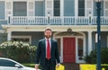 Busines sman standing outside a modern house. Real estate concept. Agent ready to sell home. Royalty Free Stock Photo