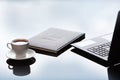 Business accessories on a glass table. A laptop and a leather-bound notebook. Reflection of the sky. Copy of the space Royalty Free Stock Photo