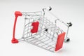 Business accident, product commerce fail or problem concept, closed up of crash red mini shopping cart, trolley on isolated white