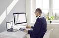 Business accountant sitting at office desk and working on desktop and laptop computers Royalty Free Stock Photo