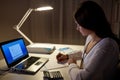 Woman with calculator and papers at night office Royalty Free Stock Photo