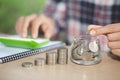 Business accounting with saving money with hand putting coins in jug glass, Businessman Writing Financial Accounting, concept Royalty Free Stock Photo