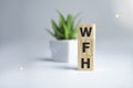 Business Acronym WFH as Work From Home on woode cubes. Conceptual image