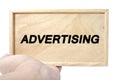 Business and advertising concept. hand holding plain wood with word advertising