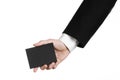 Business and advertising topic: Man in black suit holding a black blank card in hand isolated on white background in studio Royalty Free Stock Photo