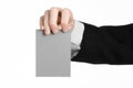 Business and advertising topic: Man in black suit holding a gray blank card in hand isolated on white background in studio Royalty Free Stock Photo