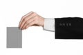 Business and advertising topic: Man in black suit holding a gray blank card in hand isolated on white background in studio Royalty Free Stock Photo