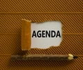 Business and agenda symbol. The concept word `agenda` appearing behind torn brown paper. Wooden pencil. Beautiful brown backgrou Royalty Free Stock Photo