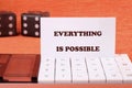 Business anything possible concept. Copy space. Text EVERYTHING IS POSSIBLE on a business card with game cubes in the background Royalty Free Stock Photo