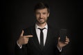 Businessman Pointing Finger At Blank Phone Screen, Black Background, Mockup Royalty Free Stock Photo