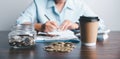 Business asian woman hand put coins in piggy bank on wood table background, saving money wealth and financial concept, finance, Royalty Free Stock Photo