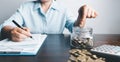 Business asian woman hand put coins in piggy bank on wood table background, saving money wealth and financial concept, finance, Royalty Free Stock Photo