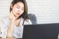 Business Asian woman having neck and shoulder pain while working on computer