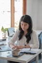 Business asian woman using calculating interest, taxes and profits to invest in real estate and home buying. Royalty Free Stock Photo