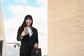 Business Asian woman using mobile smartphone out office - Young smiling Chinese girl ready for working Royalty Free Stock Photo