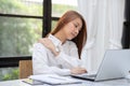 Business Asian woman working with laptop and have a shoulder pain after work hard