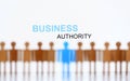 Business authority sign above line of toy human figures Royalty Free Stock Photo