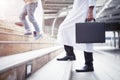 Business background concept. Arab businessman holding business bag walking up the stairs in the city Royalty Free Stock Photo