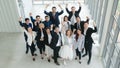 Business background of group of diverse business people, asian and caucasian, raise hands and fists up in concept of cheer up Royalty Free Stock Photo