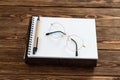 Business background, notebook, pen glasses. Wooden Office Table.