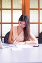 Business beautiful Asian woman working on laptop computer and writing note Royalty Free Stock Photo