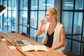 Business blonde girl drinking water in front of a laptop Royalty Free Stock Photo