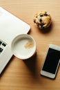 Business breakfast with cafe, muffin, laptop and cellphone Royalty Free Stock Photo