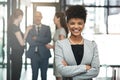 In the business of brilliance. Portrait of a confident young businesswoman standing in a modern office with colleagues Royalty Free Stock Photo