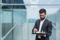 Business broker man standing near office holding board with playing chess, thinking about business strategy Royalty Free Stock Photo