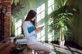 Business brunette works on the Internet, Uses smartphone sitting on the table Royalty Free Stock Photo