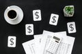 Business and budget concept with accounting, calculator, coffee and dollar sign on black background top view